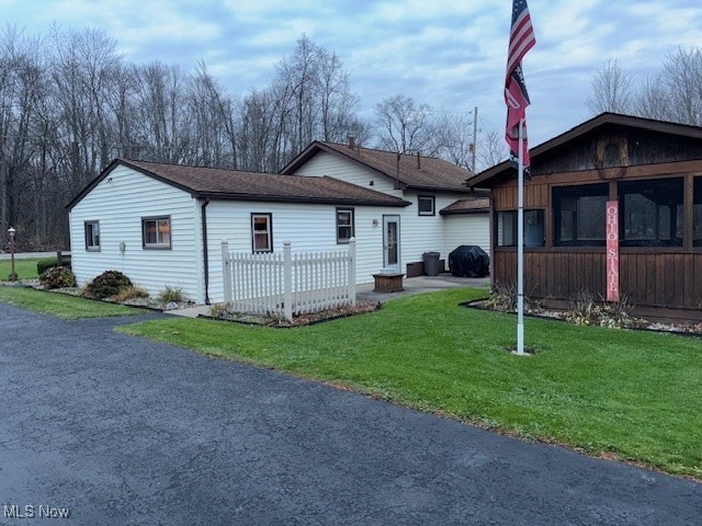 view of front of property featuring a sunroom and a front yard