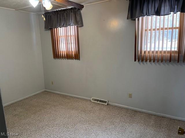 carpeted spare room with ceiling fan