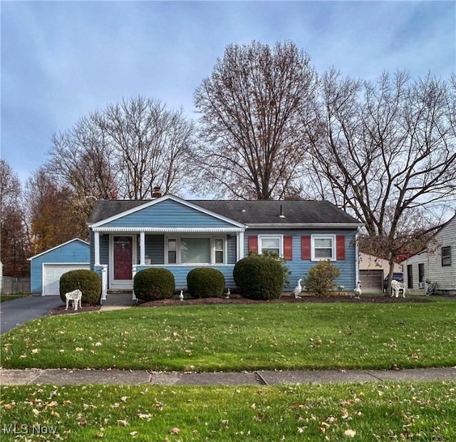 view of front facade with an outbuilding, a front lawn, and a garage