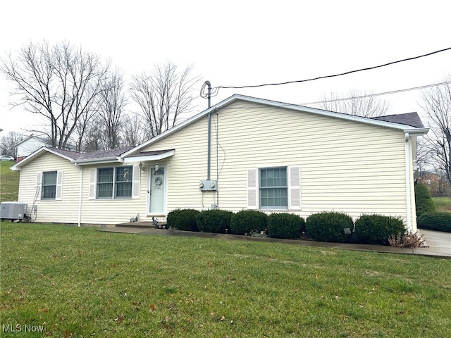 exterior space featuring central air condition unit and a yard