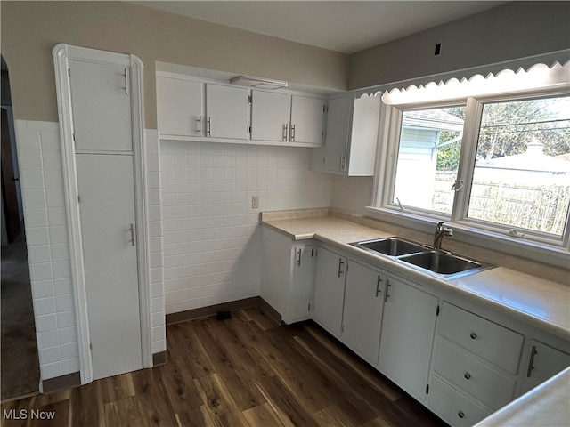 kitchen featuring sink, white cabinetry, dark wood-type flooring, and tile walls