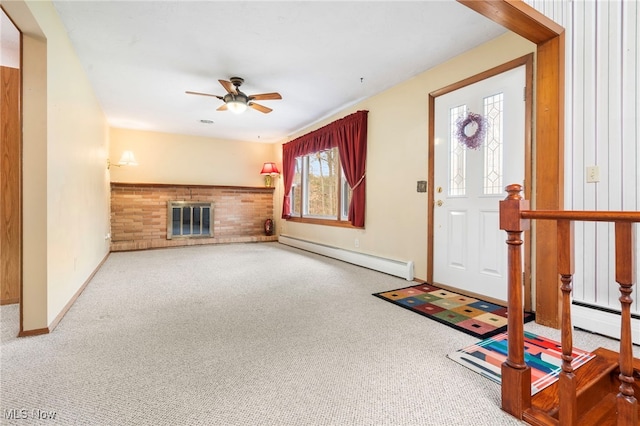 foyer entrance with carpet flooring, ceiling fan, a fireplace, and a baseboard heating unit