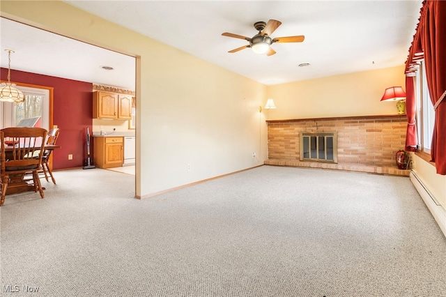 living room with a fireplace, ceiling fan, light carpet, and a baseboard heating unit