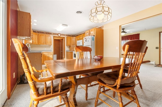 carpeted dining space featuring ceiling fan and a baseboard heating unit