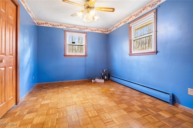 unfurnished room with light parquet flooring, a healthy amount of sunlight, and a baseboard heating unit