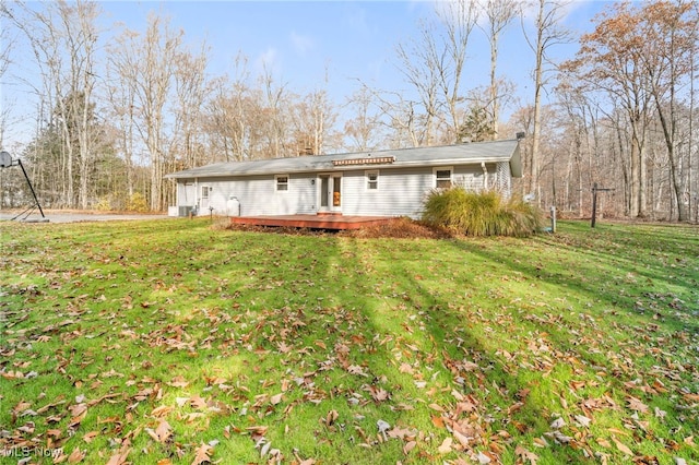 rear view of property featuring a deck and a lawn