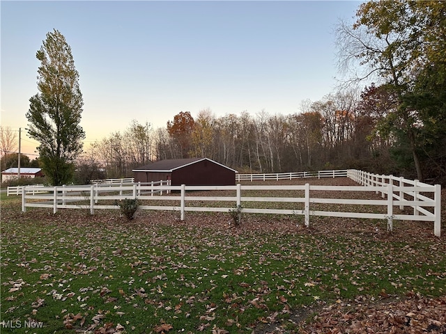 yard at dusk featuring a rural view