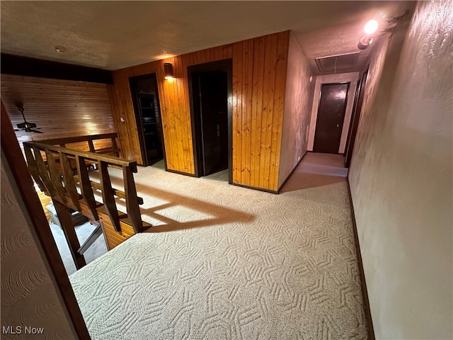 corridor with wood walls and light carpet