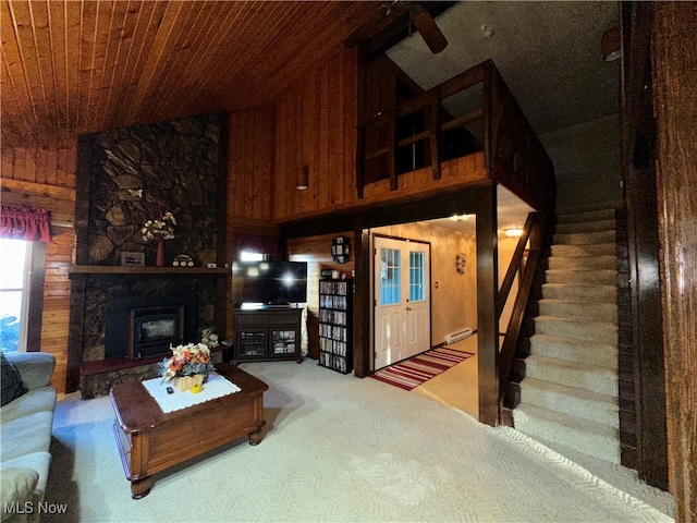 living room featuring wood walls, carpet flooring, ceiling fan, a baseboard radiator, and wood ceiling