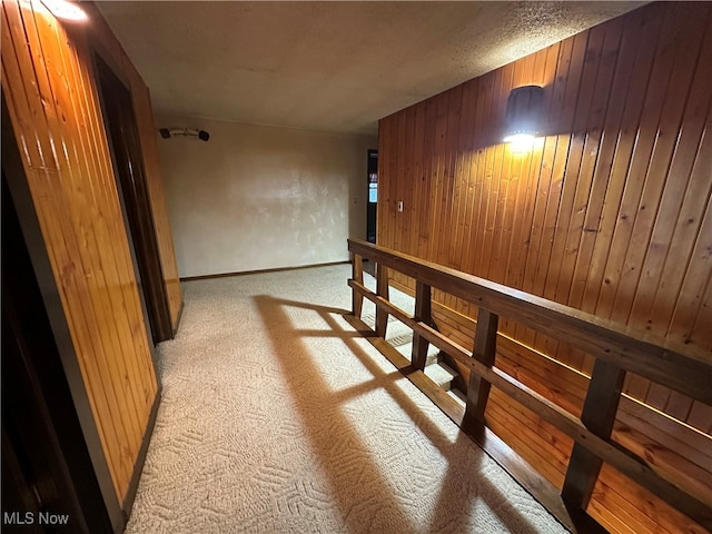 hallway featuring a textured ceiling and wooden walls