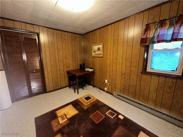 interior space featuring carpet, wooden walls, and a baseboard radiator