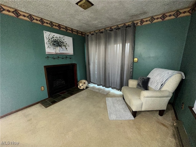 living area featuring a tile fireplace, dark carpet, and a textured ceiling