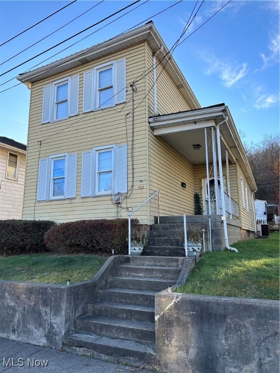 view of front of property featuring a front yard and central air condition unit