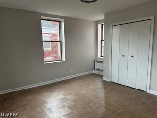 unfurnished bedroom featuring a wall mounted air conditioner and a closet