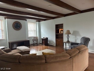 living room with beam ceiling, a healthy amount of sunlight, a baseboard heating unit, and hardwood / wood-style flooring