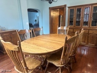 dining area featuring an inviting chandelier and dark wood-type flooring