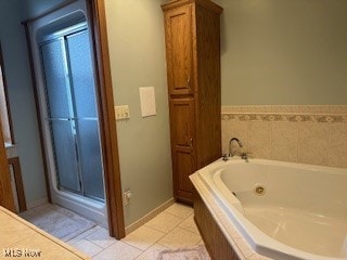 bathroom with tile patterned flooring and separate shower and tub