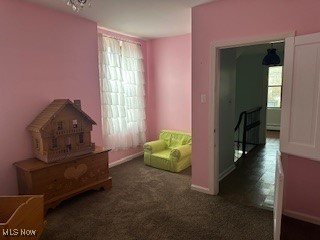 sitting room featuring dark carpet