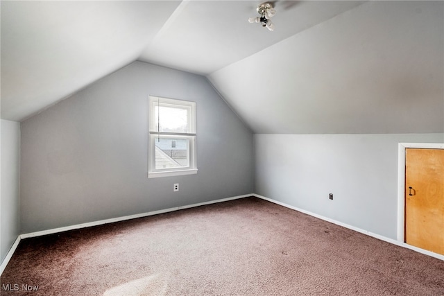 additional living space featuring carpet flooring and vaulted ceiling