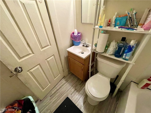 bathroom with hardwood / wood-style floors, vanity, and toilet