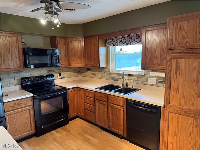 kitchen featuring decorative backsplash, ceiling fan, sink, black appliances, and light hardwood / wood-style floors