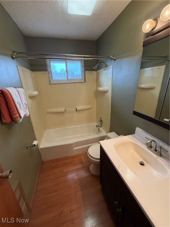 full bathroom with toilet, shower / bathing tub combination, a textured ceiling, and hardwood / wood-style flooring