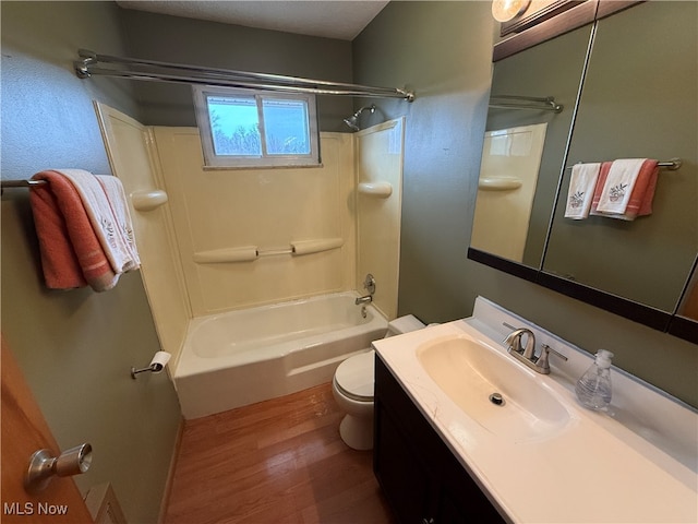 full bathroom featuring washtub / shower combination, hardwood / wood-style floors, vanity, and toilet