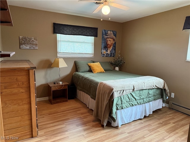 bedroom featuring ceiling fan, light hardwood / wood-style floors, and a baseboard heating unit