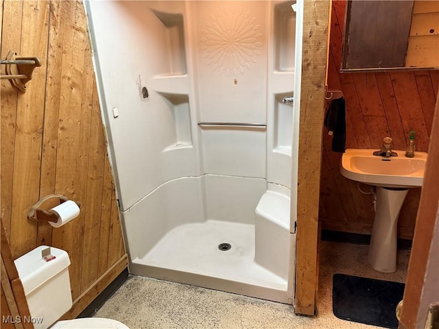 bathroom featuring wood walls, a shower, and toilet