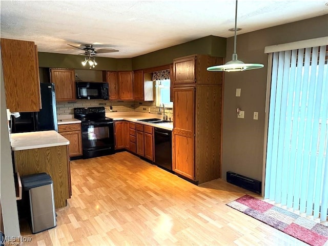 kitchen with decorative backsplash, ceiling fan, sink, black appliances, and light hardwood / wood-style flooring