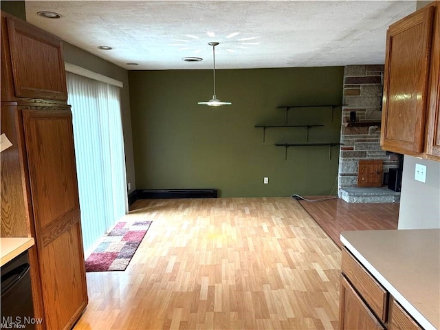 kitchen featuring a textured ceiling, pendant lighting, a baseboard heating unit, and light hardwood / wood-style floors