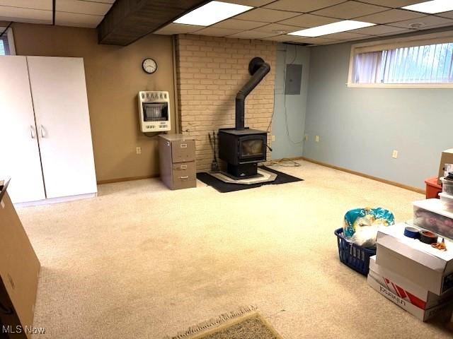 basement with carpet flooring, heating unit, and a drop ceiling