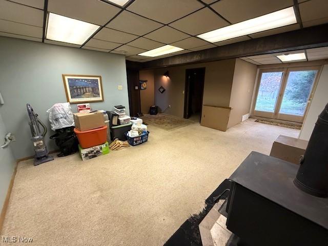 interior space with a paneled ceiling and light colored carpet