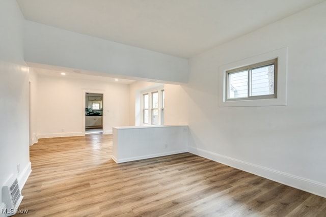 spare room with a wealth of natural light and light hardwood / wood-style flooring