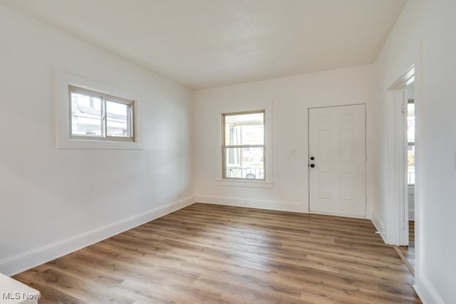 spare room with hardwood / wood-style floors and plenty of natural light