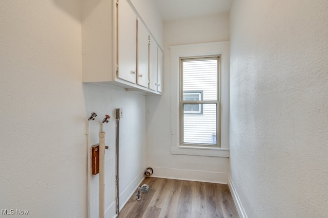 laundry area with cabinets and light hardwood / wood-style floors