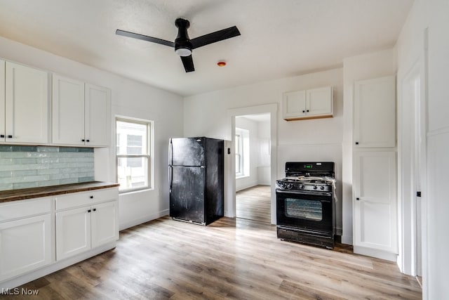 kitchen featuring ceiling fan, light hardwood / wood-style flooring, backsplash, white cabinets, and black appliances