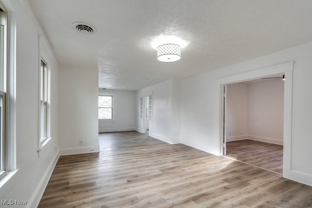 unfurnished room featuring hardwood / wood-style floors and a textured ceiling