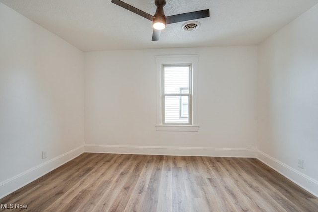 spare room with ceiling fan, light hardwood / wood-style flooring, and a textured ceiling