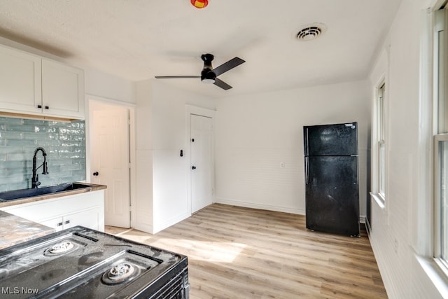 kitchen featuring ceiling fan, sink, black appliances, light hardwood / wood-style floors, and white cabinetry