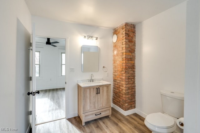 bathroom featuring ceiling fan, toilet, wood-type flooring, and vanity