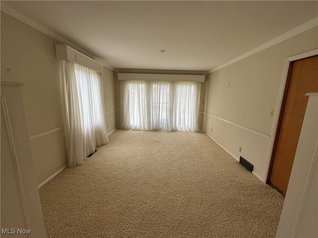 carpeted spare room featuring crown molding