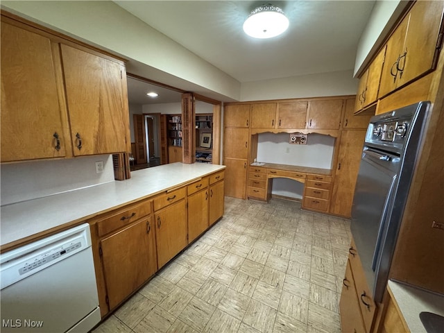 kitchen with wall oven, kitchen peninsula, white dishwasher, and ornate columns