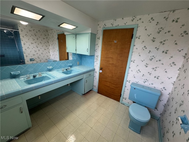 bathroom featuring vanity, toilet, backsplash, and walk in shower