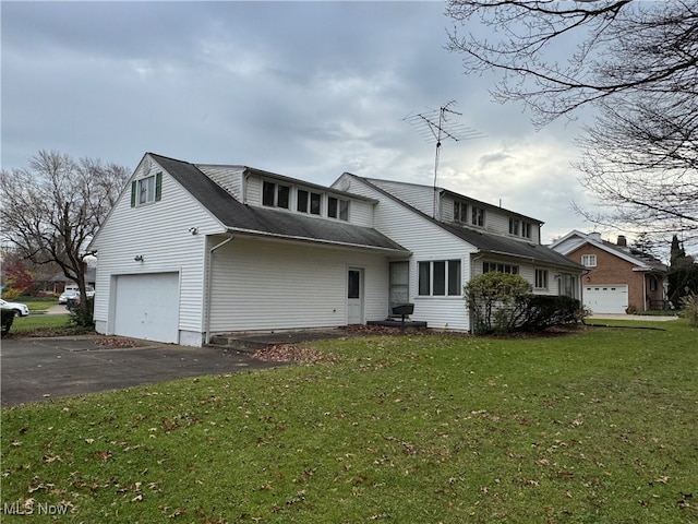 view of property featuring a garage and a front lawn