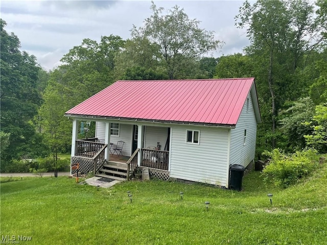 back of house with a yard and covered porch