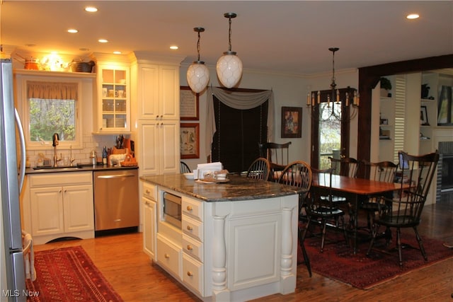 kitchen with white cabinets, a kitchen island, sink, and stainless steel appliances