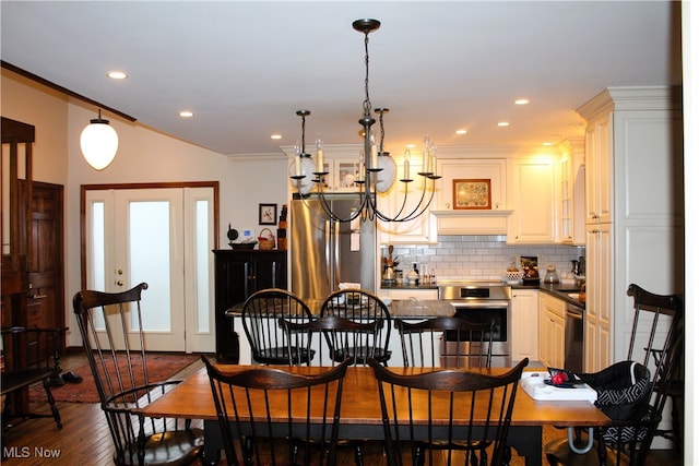 dining area featuring crown molding, dark wood-type flooring, and a notable chandelier