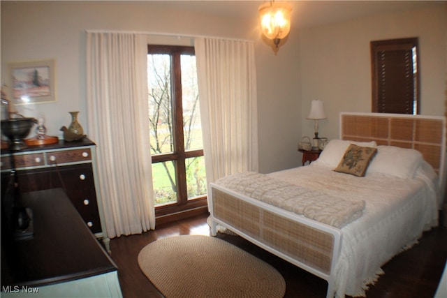 bedroom featuring wood-type flooring and an inviting chandelier