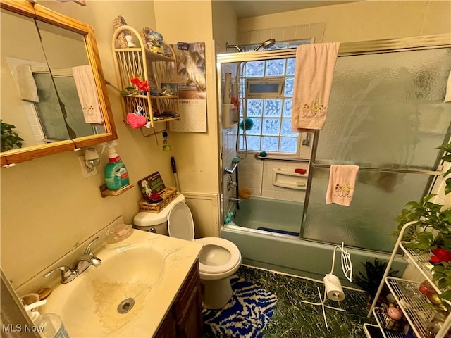 full bathroom with vanity, toilet, and enclosed tub / shower combo